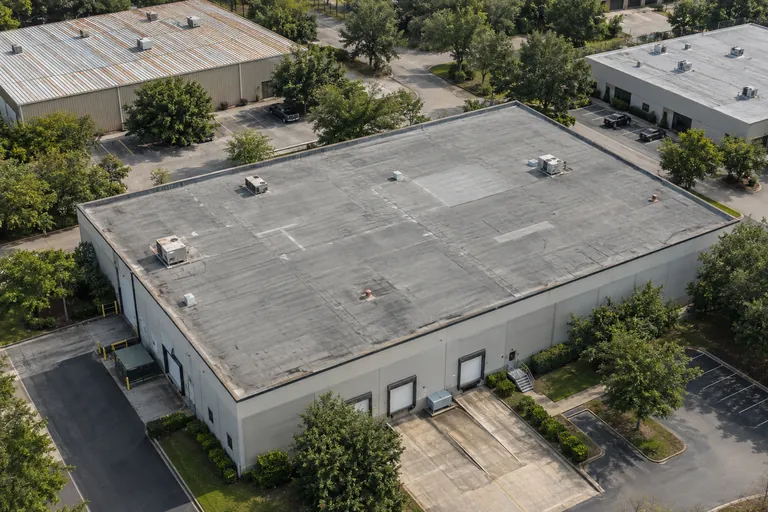 Illustrative aerial view of older commercial membrane and metal roofs